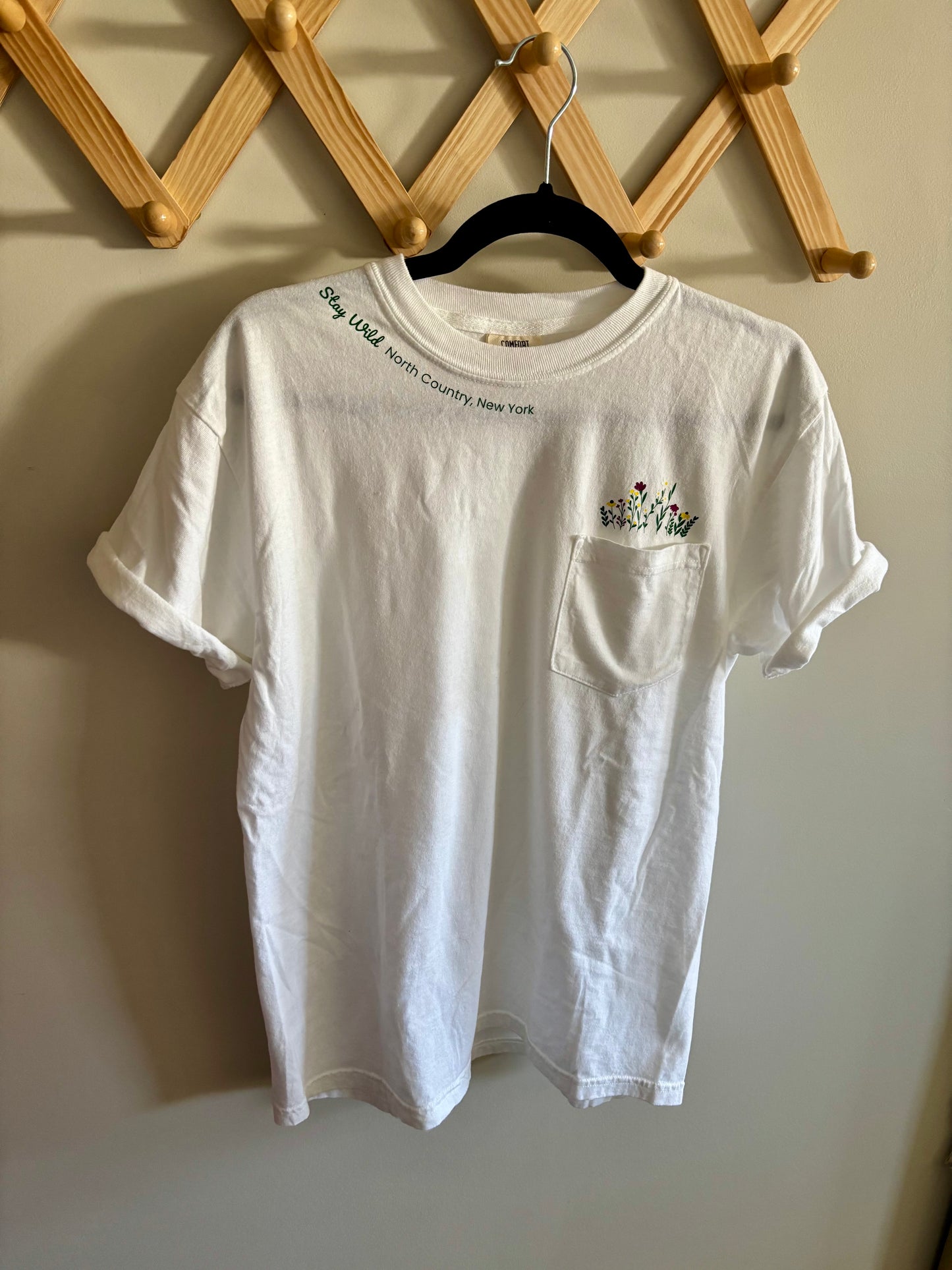 Stay Wild North Country New York Pocket Tee – White Comfort Colors Shirt with Wildflower Design