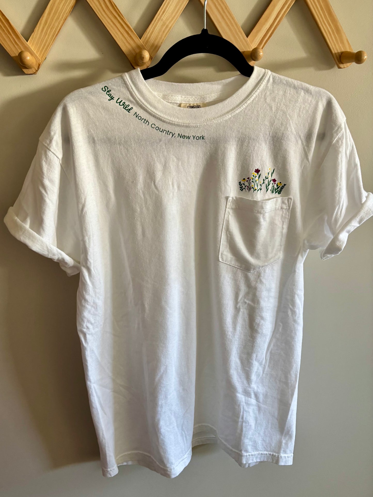 Stay Wild North Country New York Pocket Tee – White Comfort Colors Shirt with Wildflower Design