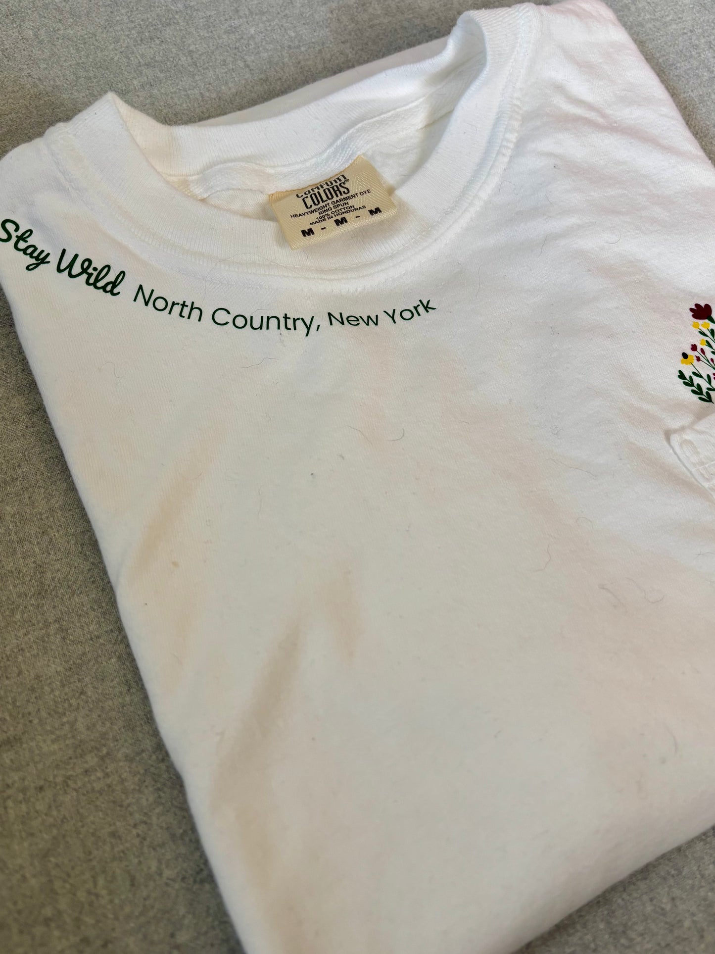 Stay Wild North Country New York Pocket Tee – White Comfort Colors Shirt with Wildflower Design