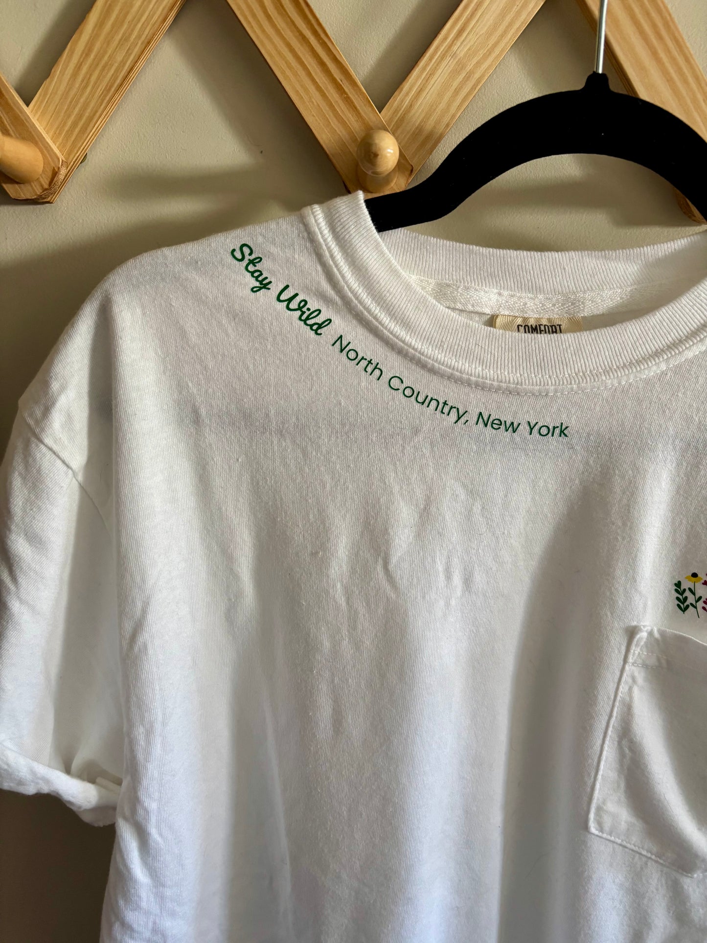 Stay Wild North Country New York Pocket Tee – White Comfort Colors Shirt with Wildflower Design