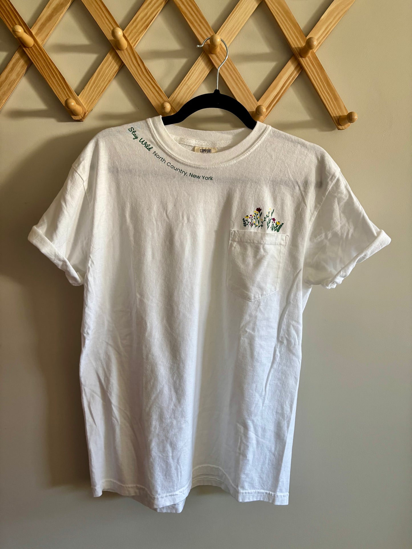 Stay Wild North Country New York Pocket Tee – White Comfort Colors Shirt with Wildflower Design