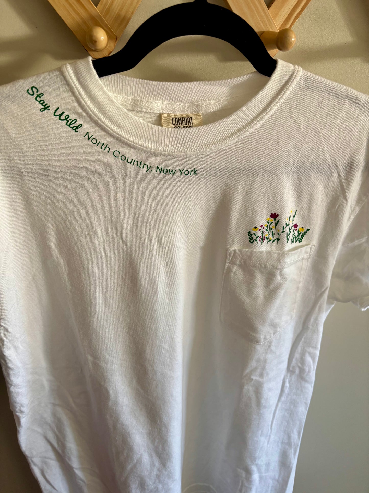 Stay Wild North Country New York Pocket Tee – White Comfort Colors Shirt with Wildflower Design